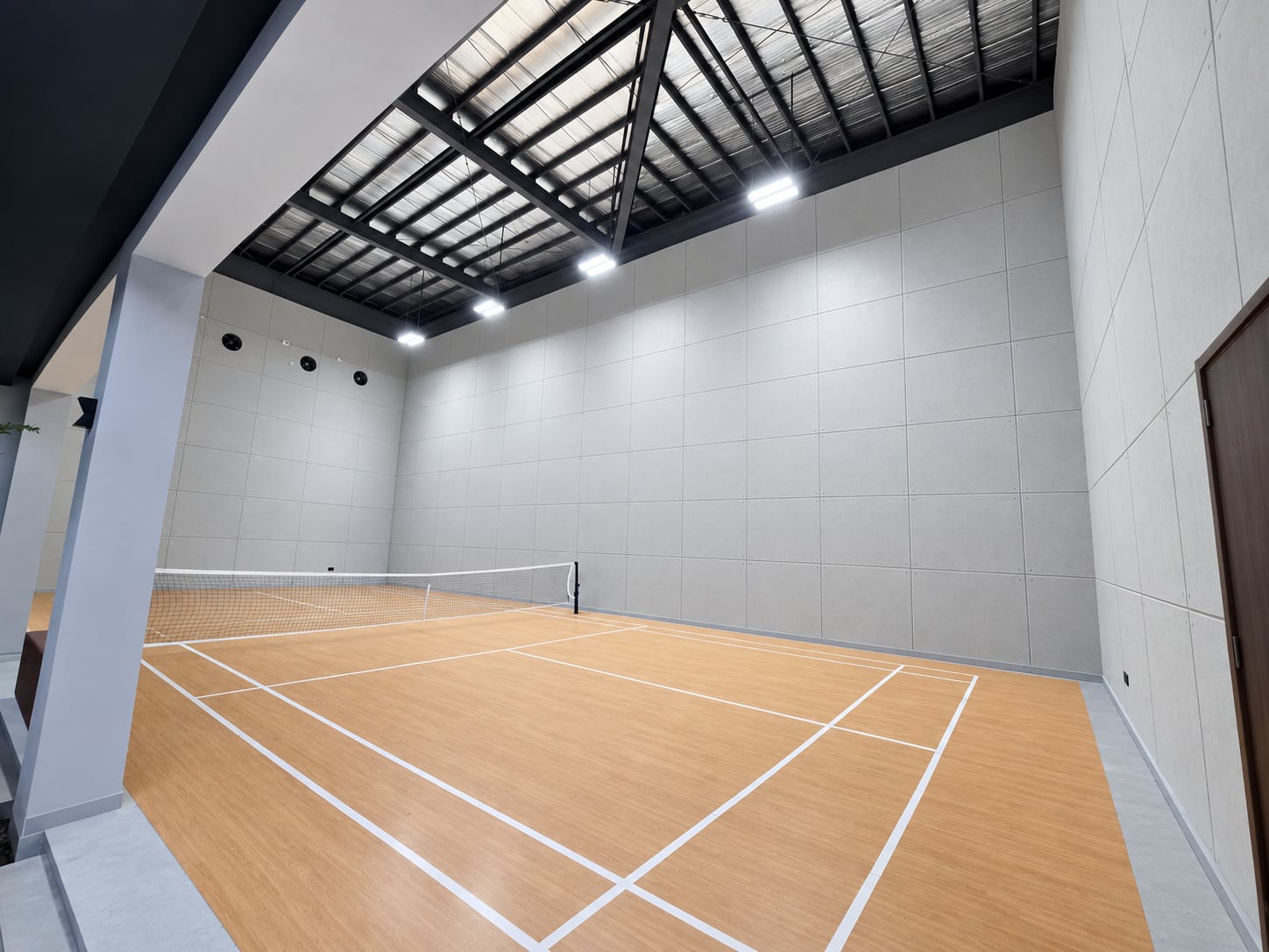 The private indoor pickleball court under bright lights